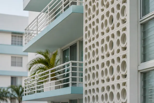 A mid-century Miami Beach condominium facade with a white breeze-block screen and balconies